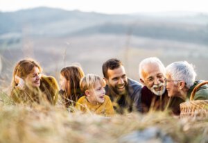 Generationsübergreifende Familienglück Kommunikation während Herbsttag auf dem Feld.