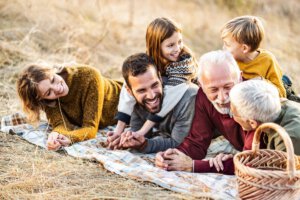 Glückliche Großfamilie im Gespräch beim Picknick in der Natur.
